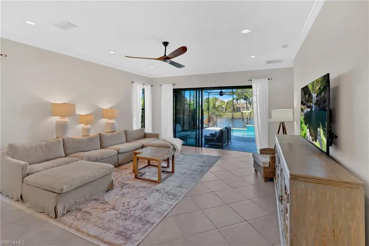 Living area with ceiling fan, crown molding, light tile patterned flooring, and recessed lighting
