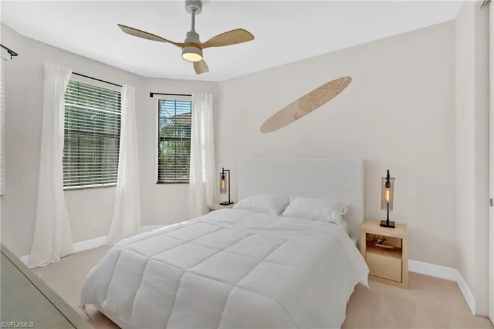 Bedroom with ceiling fan and light carpet