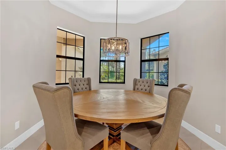 Dining area with suspended lighting and ornamental molding