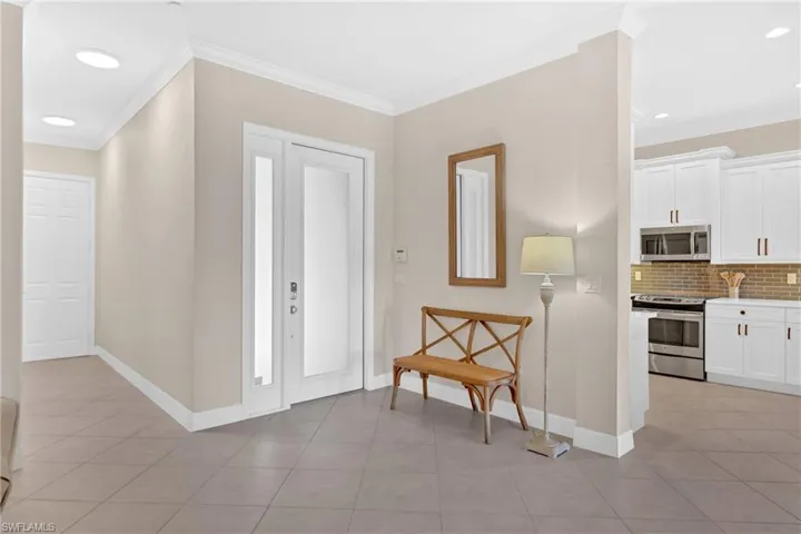 Entryway featuring ornamental molding, recessed lighting, and light tile patterned floors