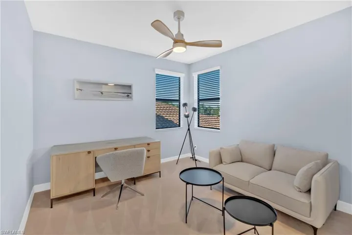 Home office with a ceiling fan and carpet flooring