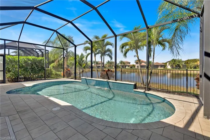 Swimming pool with a sunroom, a lanai, a patio, and a water view