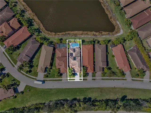 Aerial overview of property's location with property parcel outlined, nearby suburban area, and a nearby body of water