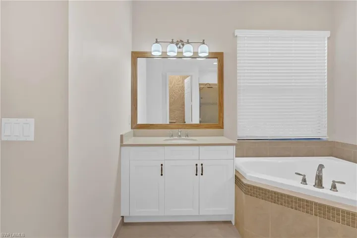 Bathroom with vanity, a bath, light tile patterned floors, and a shower stall