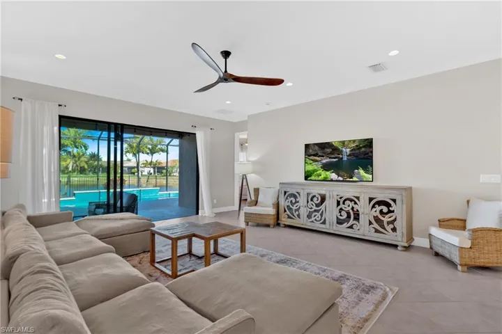Living room with ceiling fan, tile patterned flooring, crown molding, and recessed lighting
