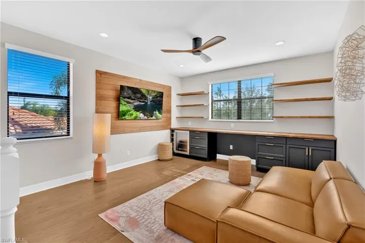 Office area featuring a ceiling fan, light wood-type flooring, built in desk, wine cooler, and recessed lighting