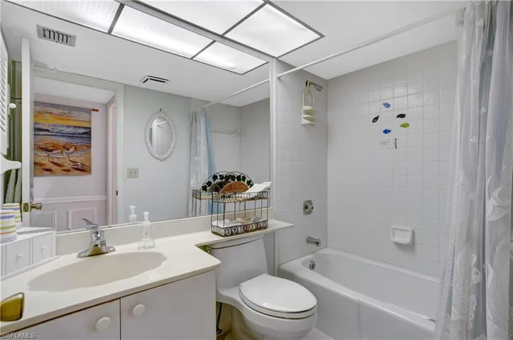 Guest bathroom next to guest bedroom with tub/shower combination.