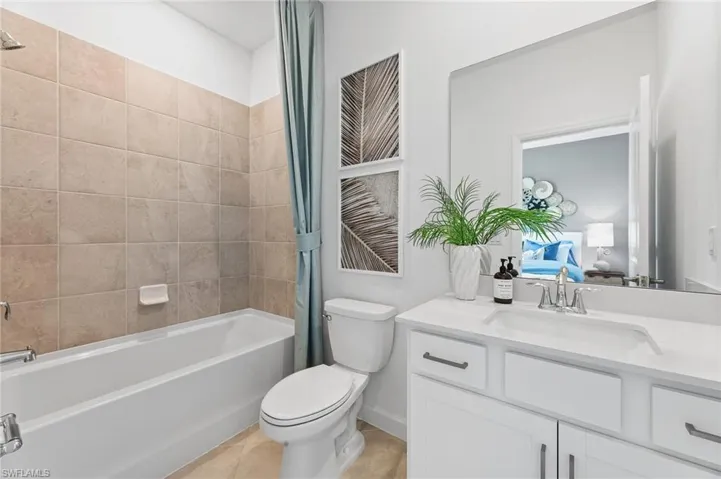 Bathroom featuring vanity, shower / tub combo, connected bathroom, and tile patterned flooring