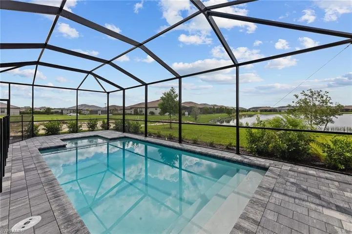 Swimming pool with a residential view, a lanai, and a water view