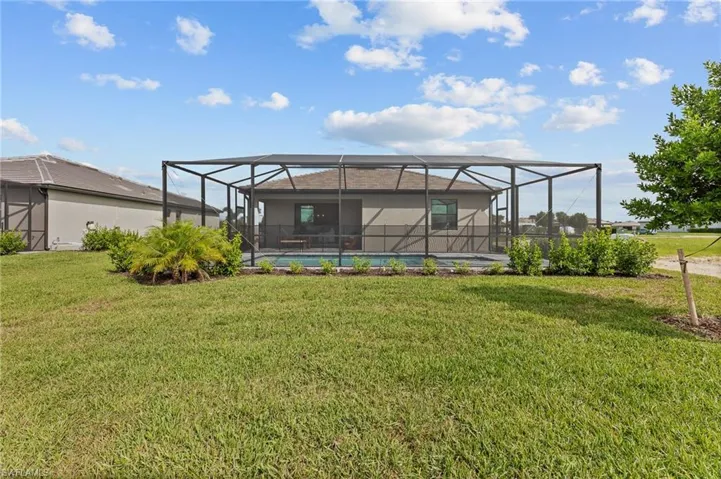 Rear view of house featuring a yard and a lanai