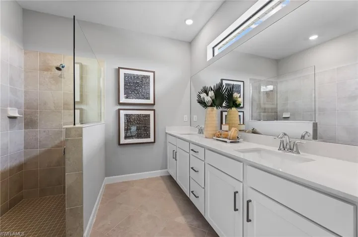 Full bathroom with double vanity, a walk in shower, tile patterned flooring, and recessed lighting