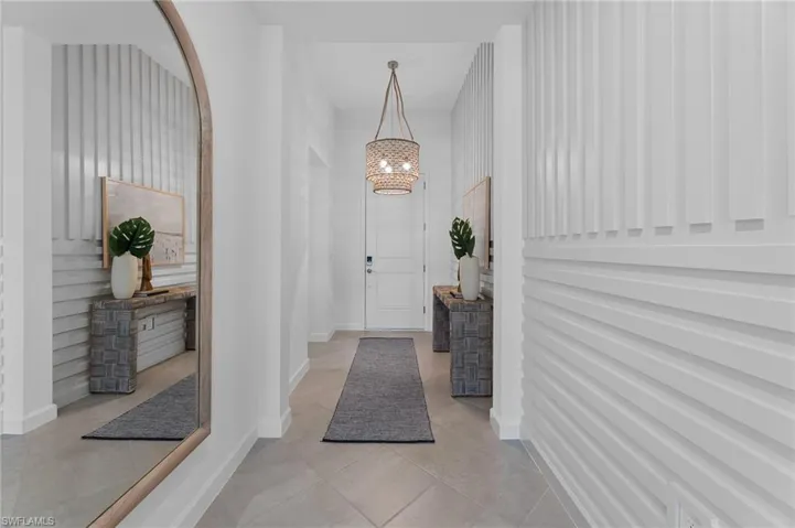 Foyer entrance featuring light tile patterned floors and a chandelier