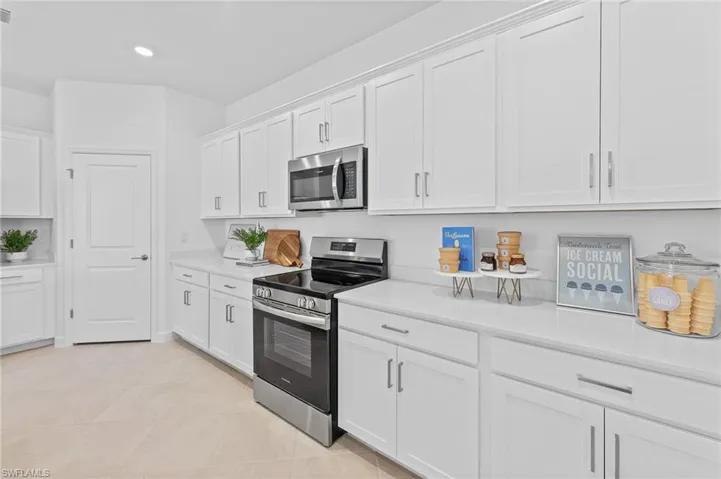 Kitchen with stainless steel appliances, light countertops, white cabinetry, recessed lighting, and light tile patterned floors