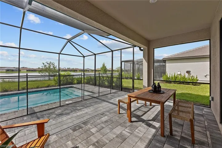 View of patio / terrace featuring an outdoor pool, glass enclosure, and a residential view