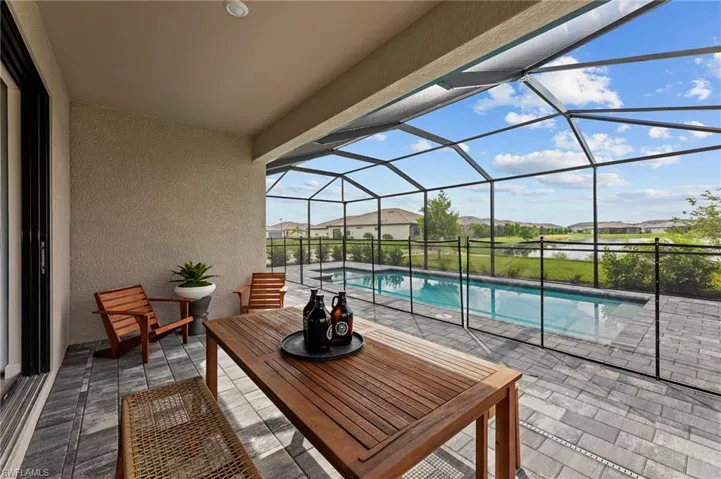 View of patio / terrace with an outdoor pool, glass enclosure, and a residential view