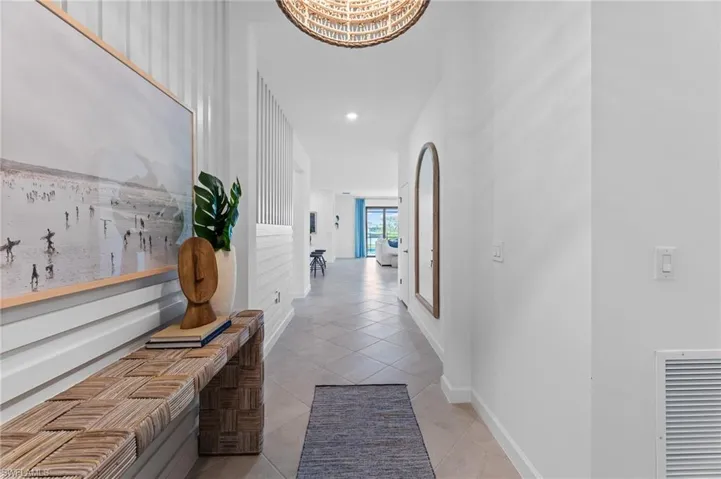 Corridor featuring light tile patterned flooring, recessed lighting, and a chandelier