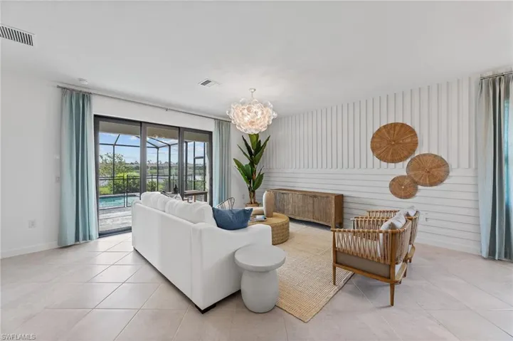 Living room featuring light tile patterned flooring and a chandelier