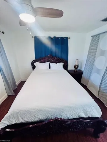 Bedroom with a ceiling fan and dark wood-style floors