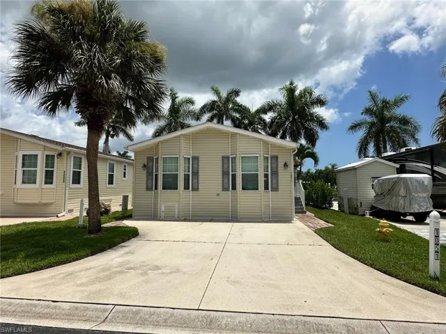 View of front of house with a carport and a front lawn