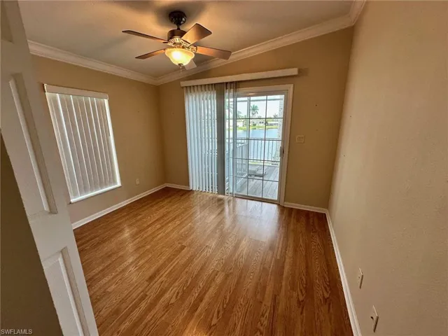 Spare room with hardwood / wood-style flooring, crown molding, and ceiling fan
