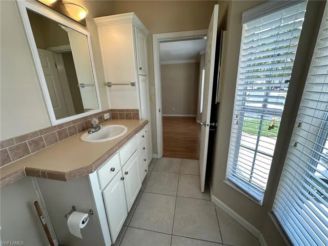 Bathroom with ornamental molding, vanity, decorative backsplash, and hardwood / wood-style floors