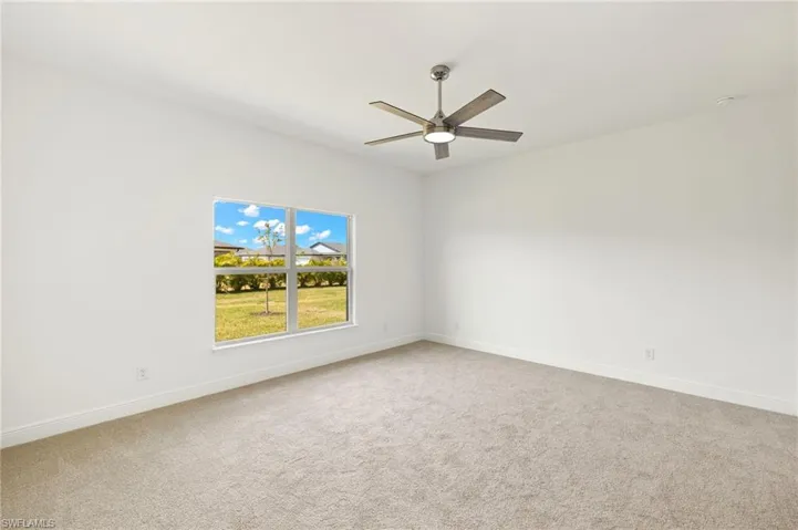 Spare room with ceiling fan, baseboards, and carpet
