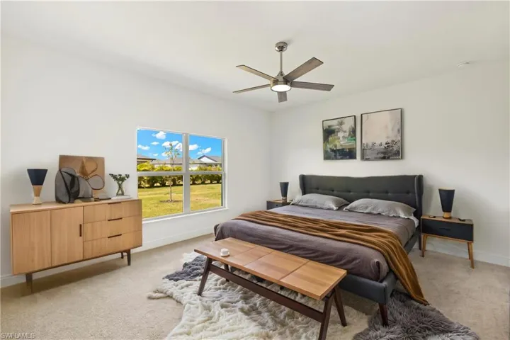 Bedroom with baseboards, light colored carpet, and ceiling fan
