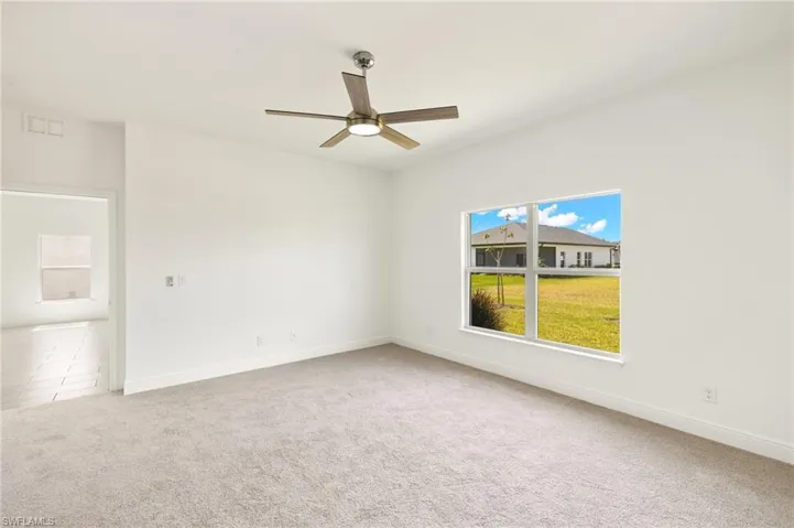 Unfurnished room featuring baseboards, carpet flooring, ceiling fan, and visible vents