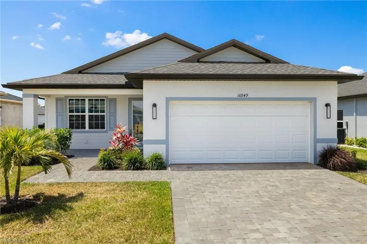 Single story home with an attached garage, decorative driveway, stucco siding, and a shingled roof
