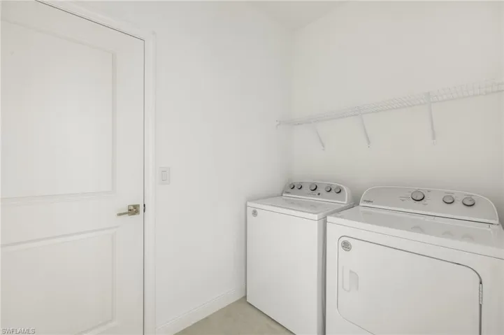 Clothes washing area featuring laundry area, baseboards, and separate washer and dryer