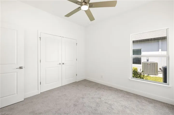 Unfurnished bedroom with a ceiling fan, baseboards, carpet, and a closet