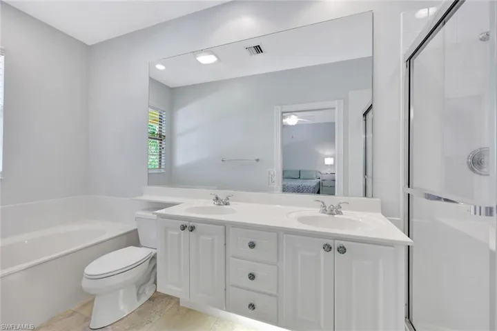 Ensuite primary bathroom features dual sinks and a large walk-in closet.
