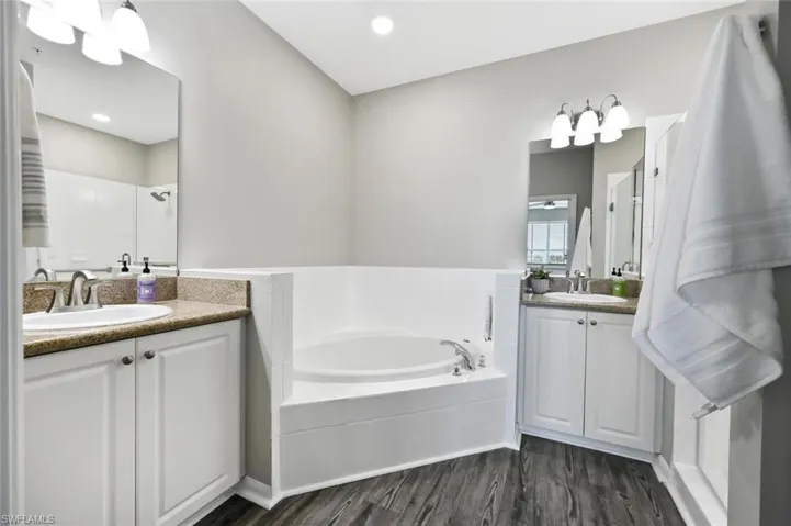 Bathroom featuring independent shower and bath, vanity, and hardwood / wood-style floors
