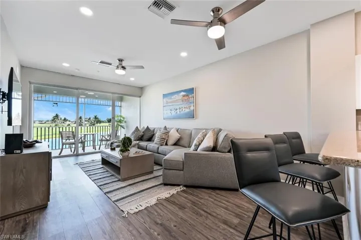 Living room with ceiling fan and hardwood / wood-style flooring