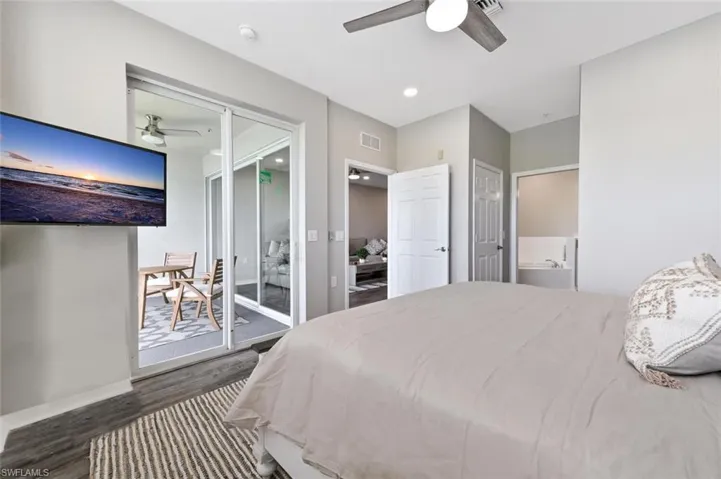 Bedroom with ceiling fan, access to exterior, and dark wood-type flooring