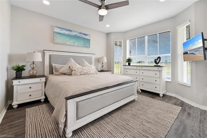 Bedroom featuring multiple windows, dark hardwood / wood-style flooring, and ceiling fan