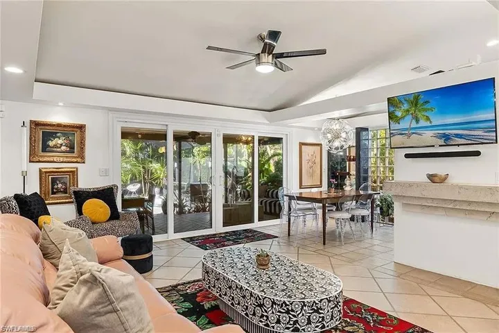 Living room featuring ceiling fan, plenty of natural light, lofted ceiling, light tile patterned floors, and recessed lighting