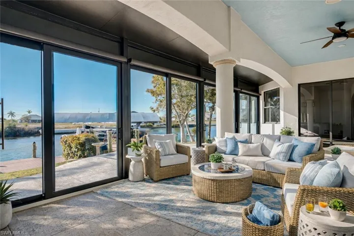 Sunroom featuring ceiling fan, an outdoor living space, a water view, and a patio