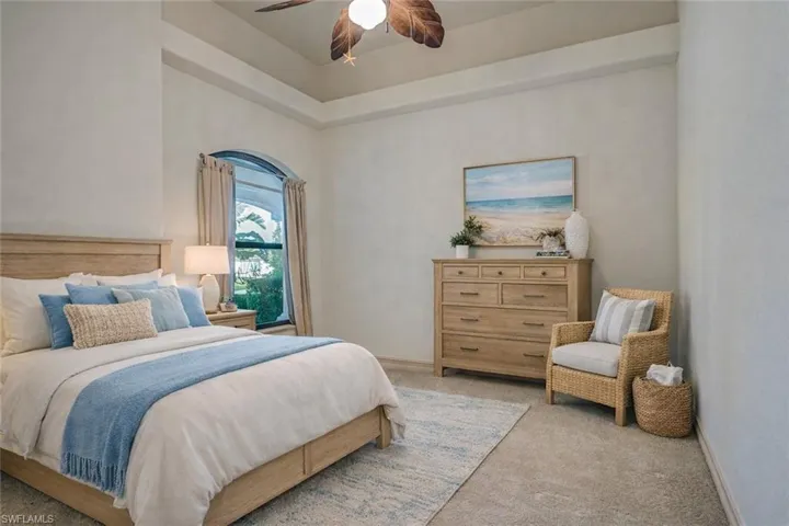 Carpeted bedroom with a ceiling fan and baseboards