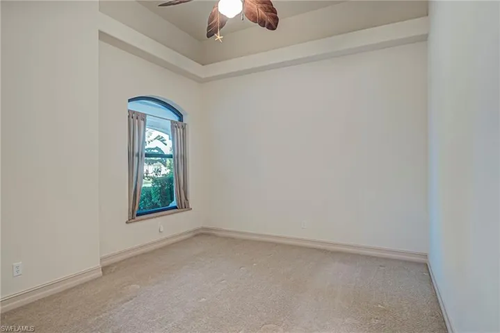 Spare room featuring light colored carpet and a ceiling fan