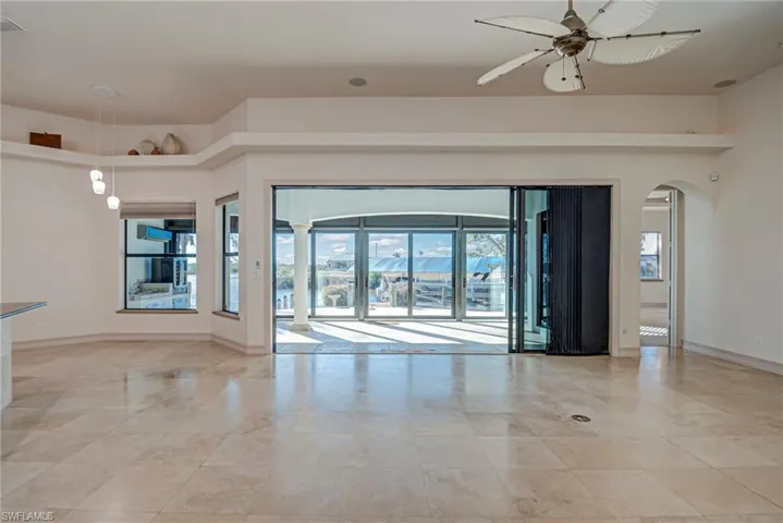 Empty room featuring a ceiling fan and arched walkways