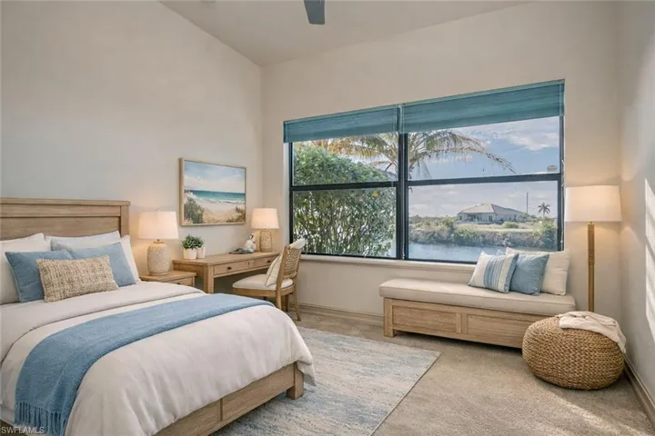 Bedroom featuring carpet flooring, a water view, a ceiling fan, and lofted ceiling