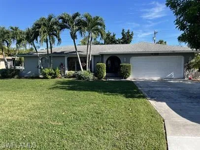 Single story home featuring concrete driveway, a front yard, and a garage