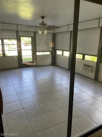 Unfurnished room featuring light tile patterned floors and a ceiling fan