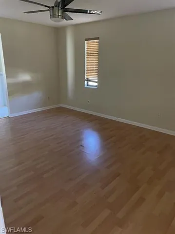 Empty room featuring wood finished floors and a ceiling fan