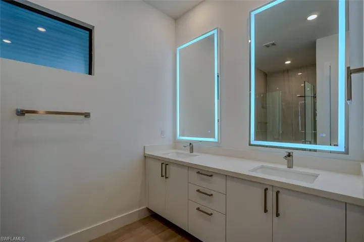 Bathroom with dual vanity and hardwood / wood-style floors