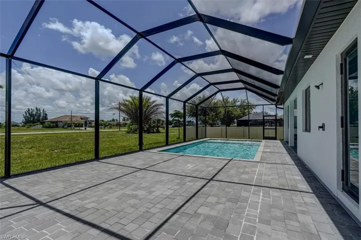 View of swimming pool with a lawn, a patio, and a lanai