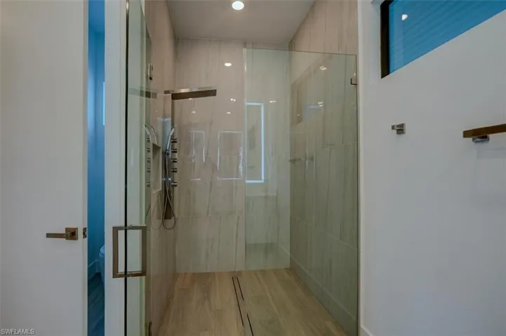 Bathroom featuring hardwood / wood-style floors and an enclosed shower