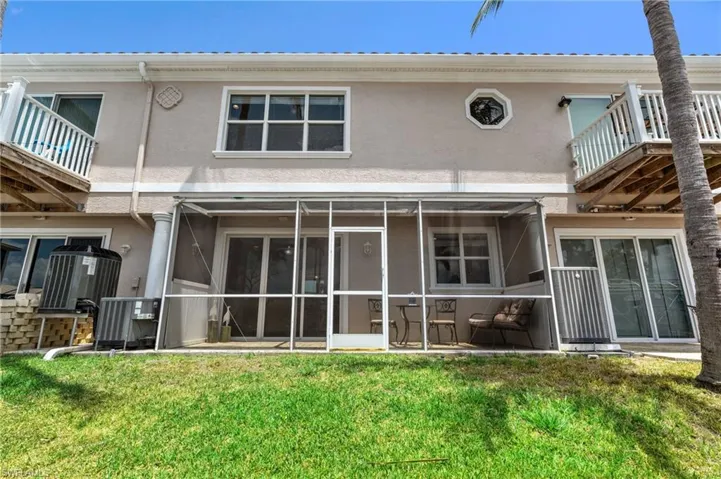 Rear view of property featuring a lawn, stucco siding, Patio