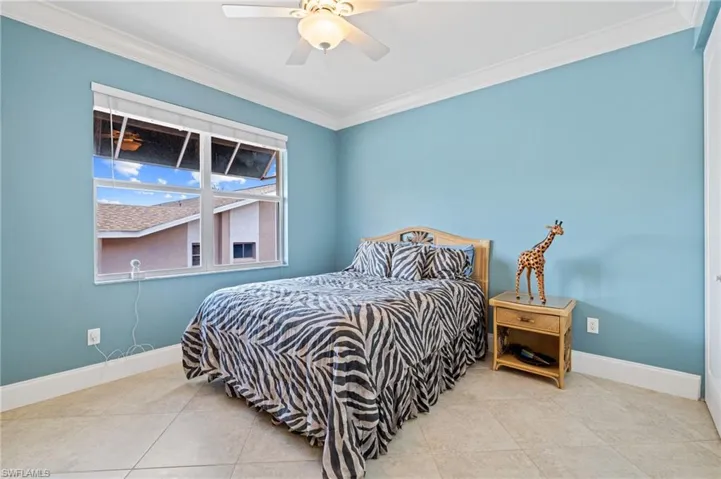 Tiled bedroom featuring ornamental molding, and ceiling fan